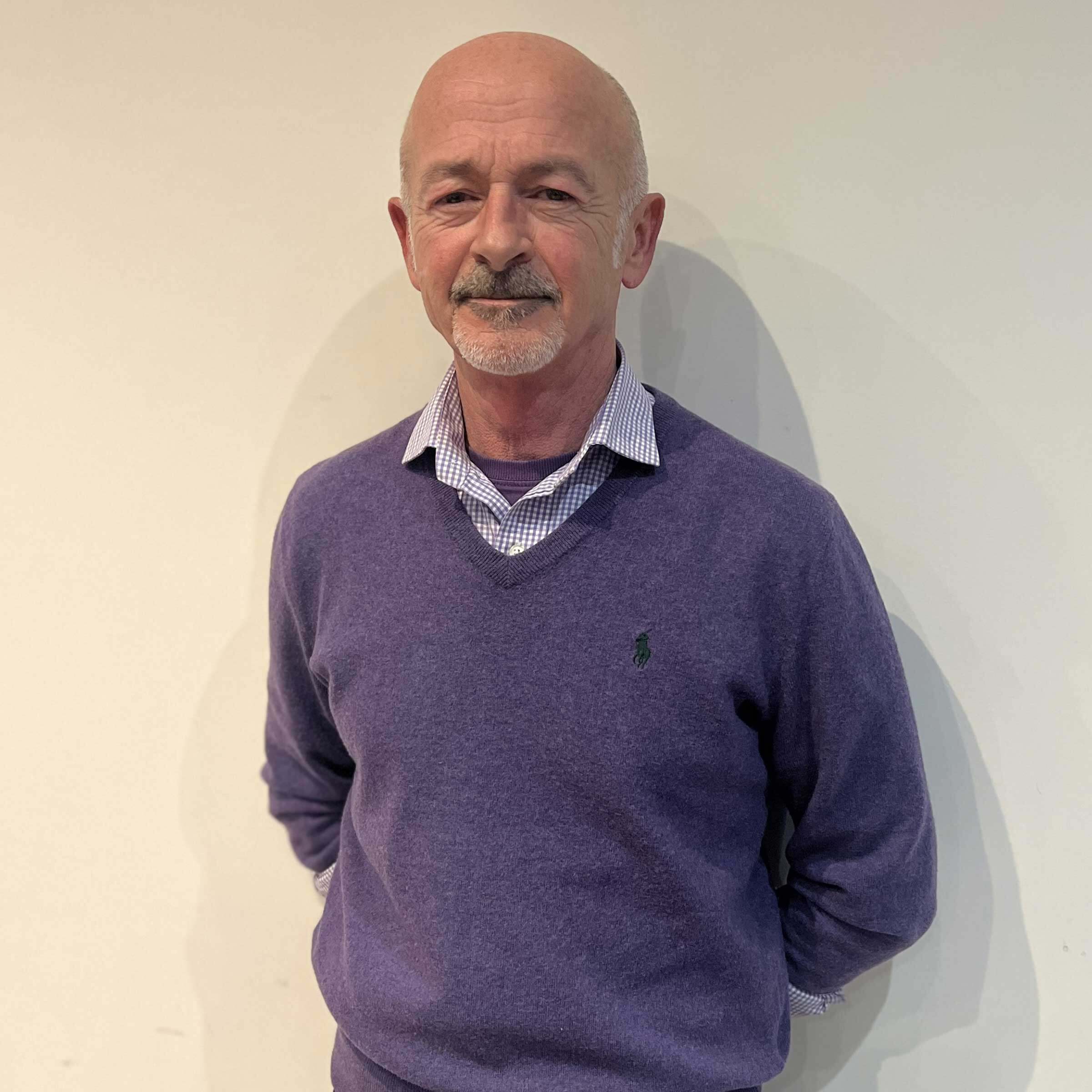 head and shoulders of Davie, wearing a blue v-neck jumper and checked shirt