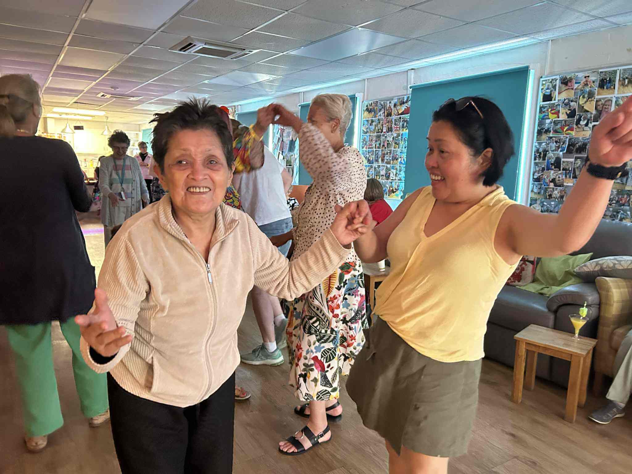 Two ladies disco dancing in a darkened room with others dancing behind them at Old Silk Works