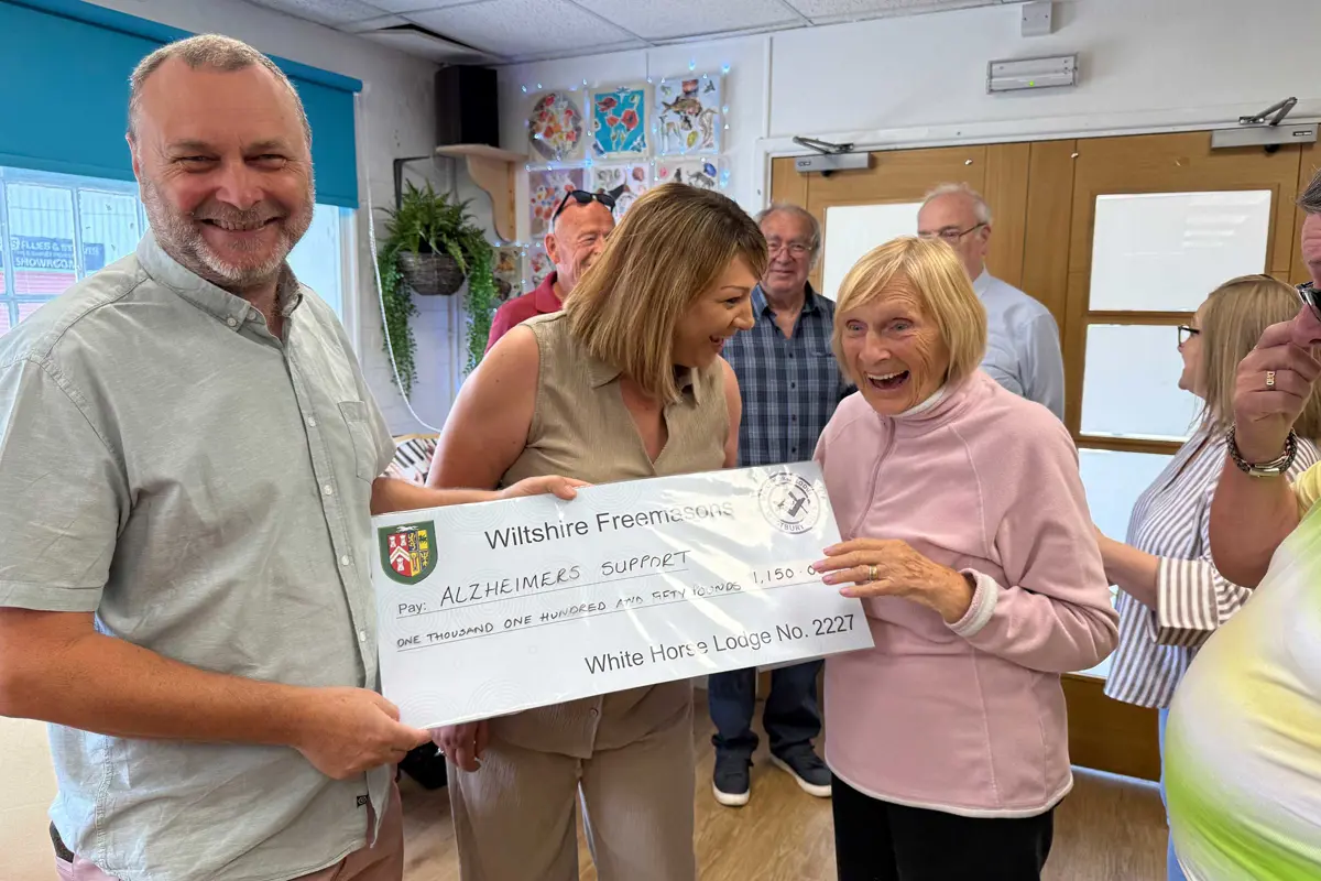 A very happy picture showing a man presenting a cheque to Old Silk Works club with Louise the Manager and a member laughing and holding the cheque.  Behind are other staff and members of the club 