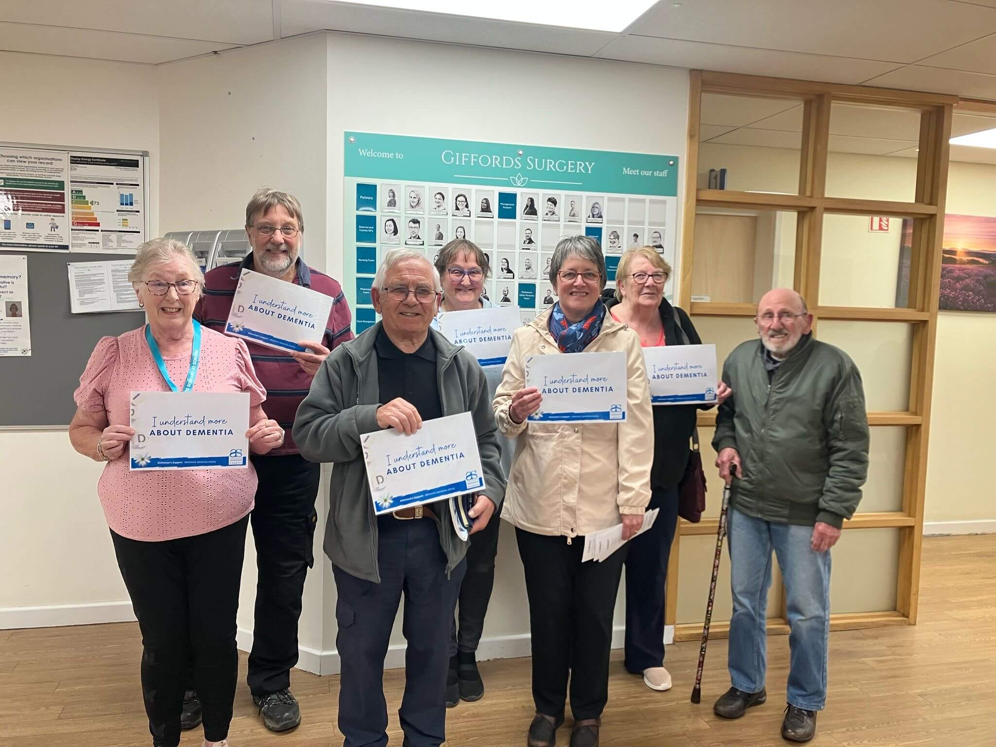 A group of people from Giffords Surgery stand together with their certificates saying I understand more about Dementia 