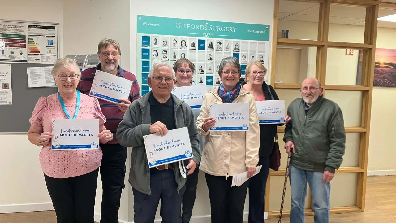 A group of people from Giffords Surgery stand together with their certificates saying I understand more about Dementia