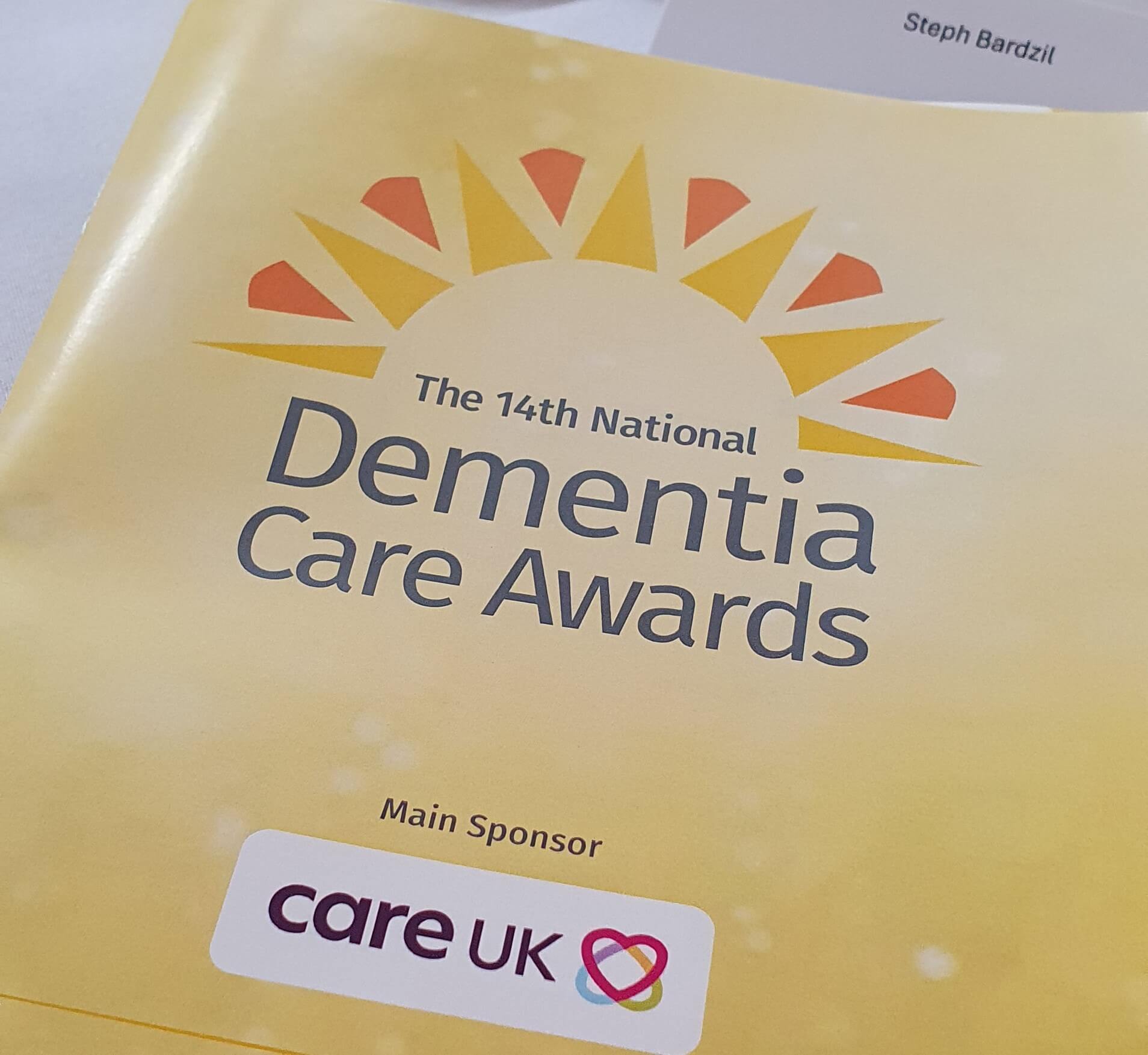 Cover of the programme for the 14th annual Dementia Care awards, showing the organisation and sponsor's logos
