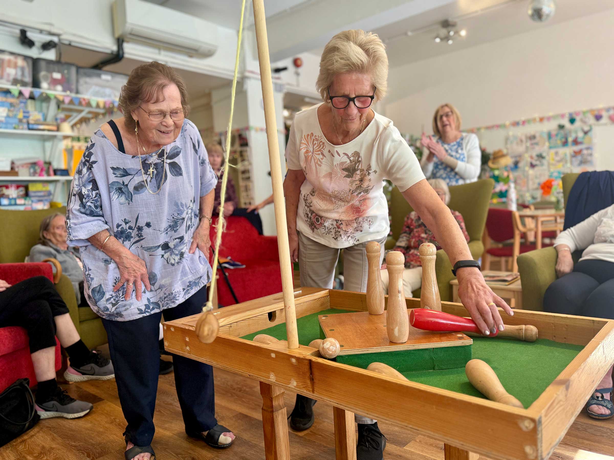 Two ladies enjoying a game of table skittles in Mill Street Club 