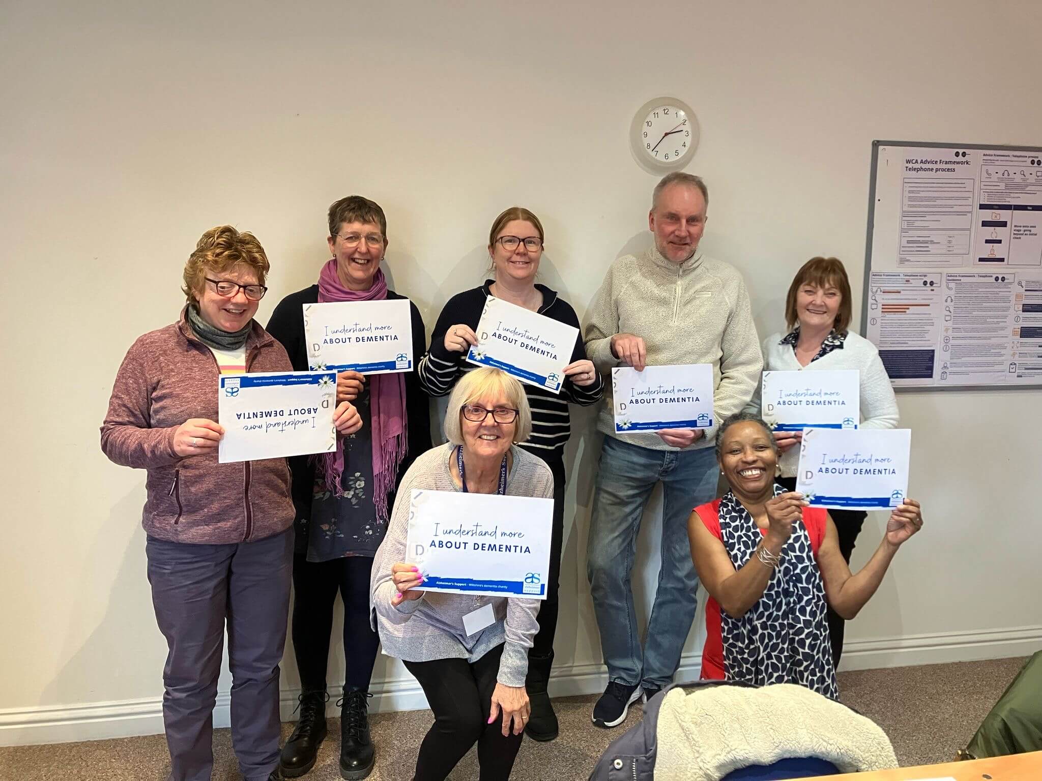 Trainer Annie Clayton with a group of six Understanding Dementia champions holding 'I understand more' cards