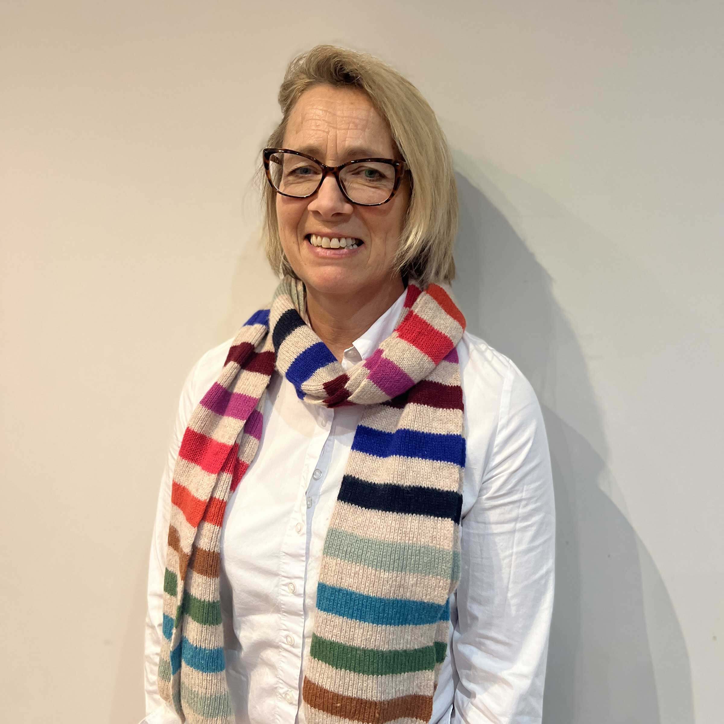 Head and shoulders of Veronica wearing a bright coloured stripy scarf