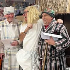Tim, Duncan and Paul dressed as shepherds standing with their arms round each other, laughing saying their lines