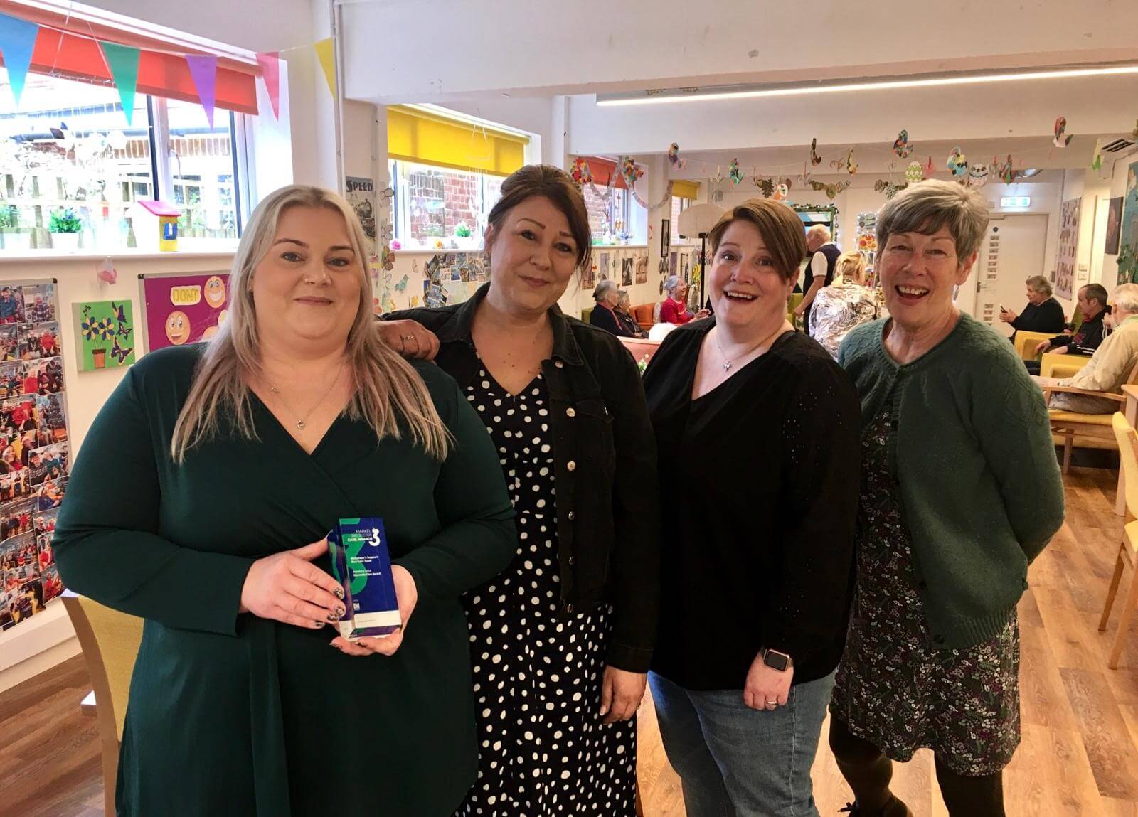 Four Club managers, Heidi, Louise, Becky and Sharon  standing together in Scots Lane Club, Heidi is holding an Award for Care team 
