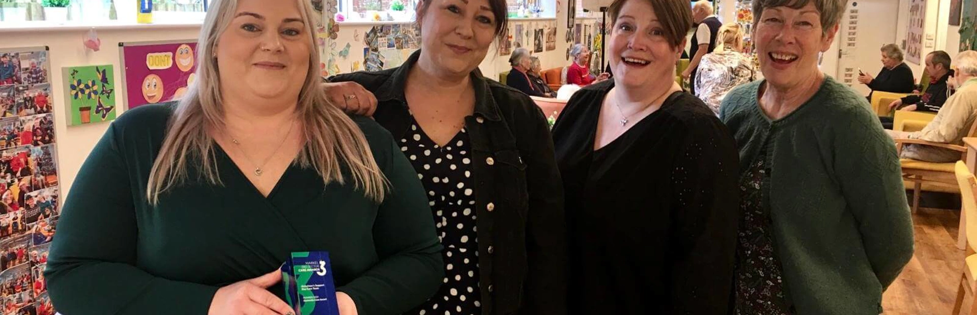 Four Club managers, Heidi, Louise, Becky and Sharon standing together in Scots Lane Club, Heidi is holding an Award for Care team Four Club managers, Heidi, Louise, Becky and Sharon standing together in Scots Lane Club, Heidi is holding an Award for Care team