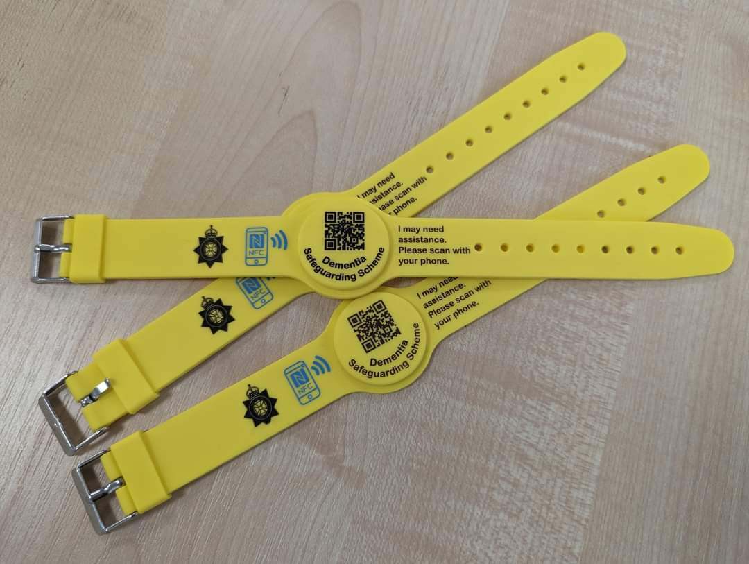 Three yellow wristbands grouped together on a table